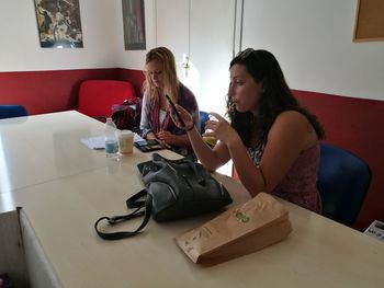 Young woman using phone while sitting on table