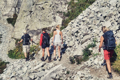 Rear view of people walking on rocks