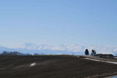 Scenic view of snowcapped mountains against clear blue sky