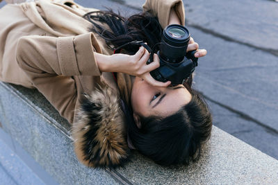 High angle portrait of woman photographing