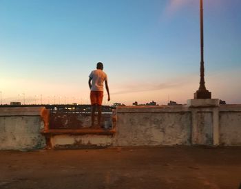 Rear view of man looking at city against sky