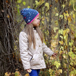 Midsection of woman wearing hat standing by tree