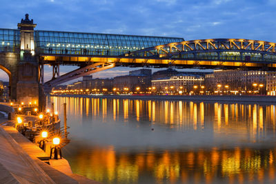 Illuminated bridge over river against sky at night