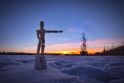 Man standing on snow against sky during sunset