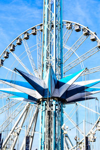 Low angle view of ferris wheel against blue sky