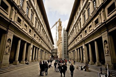 People outside uffizi gallery with palazzo vecchio in background