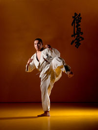 Full length of young man practicing karate in studio