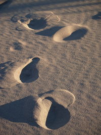 High angle view of footprints on sand at beach