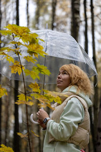 Rear view of woman with umbrella during autumn