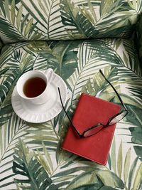 Coffee cup with notebook and eye glasses on chair