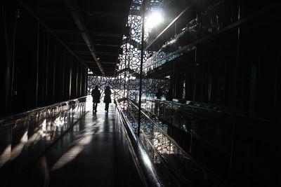 People walking in illuminated building at night