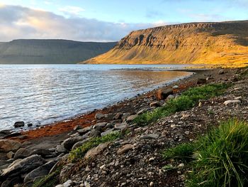 Scenic view of sea and mountains against sky