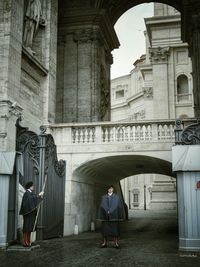 Rear view of people standing at historical building