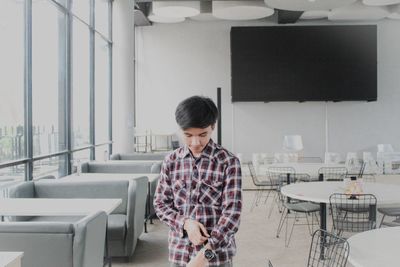 Side view of young man standing at airport