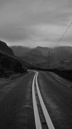 Empty road with mountains in background