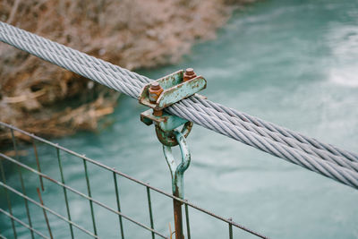 Close-up of rope tied to metal fence