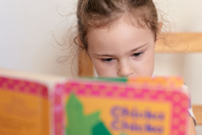 Young girl is reading a book intently