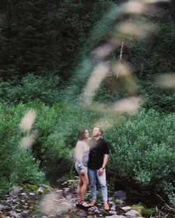 Full length of woman standing in forest