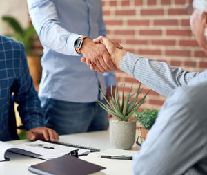 Midsection of business colleagues shaking hands