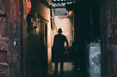 Rear view of man standing in corridor