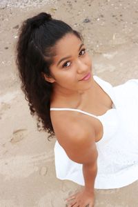 High angle view of young woman sitting on sand at beach