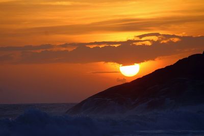 Scenic view of sea against orange sky