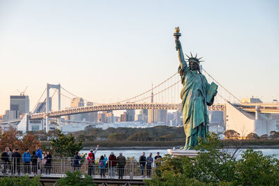 Statue in city against clear sky