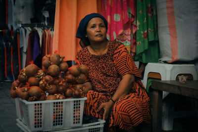 Full length of woman sitting at market