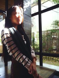 Young woman standing by window