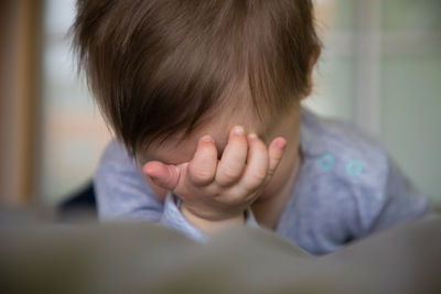 Close-up of boy sitting on hand