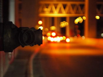 Close-up of illuminated camera on city street at night