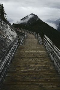 Steps leading towards mountain against sky