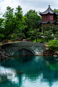 Arch bridge over river by building