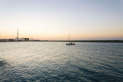 Boats in sea at sunset