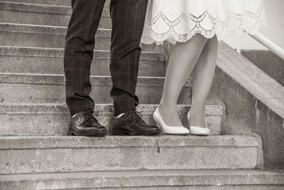 Legs of a wedding couple. shoes of a bride and a groom standing on a staircase in black and white.