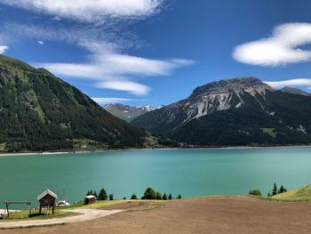 Scenic view of lake by mountains against sky