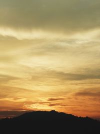 Low angle view of silhouette mountain against dramatic sky