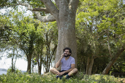 Young man at a park on a beautiful sunny day with mobile phone work and leisure. green and nature. 