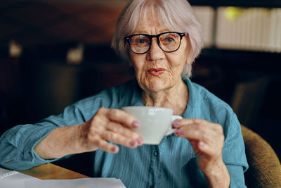 Smiling senior woman having coffee at cafe