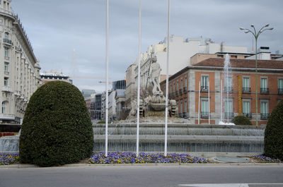 Buildings in city against cloudy sky