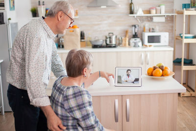 Rear view of father and son standing at home