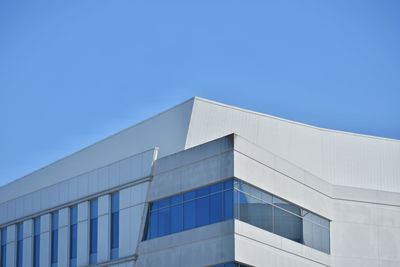 Low angle view of modern building against clear blue sky