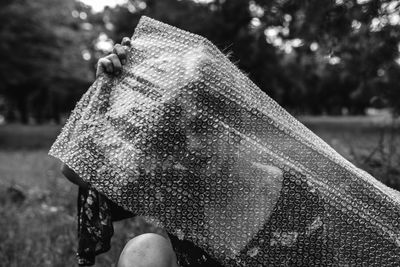 Woman holding bubble wrap plastic foil at park