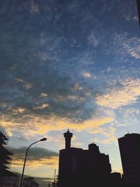 Silhouette city against sky at sunset