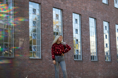 Contemplating woman standing by window of building