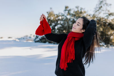 Woman with umbrella standing in snow