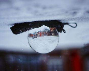 Close-up of wet glass against sky during rainy season