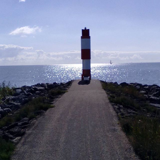 sea, horizon over water, water, sky, tranquil scene, tranquility, lighthouse, the way forward, guidance, scenics, beauty in nature, beach, nature, shore, direction, idyllic, blue, day, cloud, calm