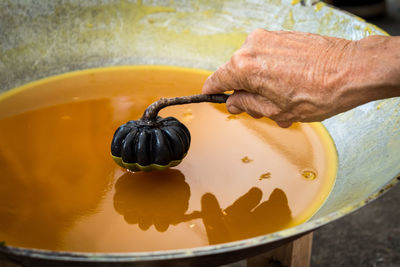 Cropped hand of woman making candle