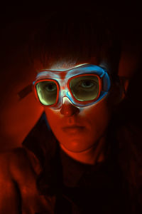 Close-up portrait of boy wearing illuminated goggles